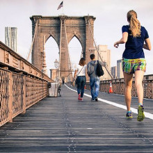Two people jogging on a bridge