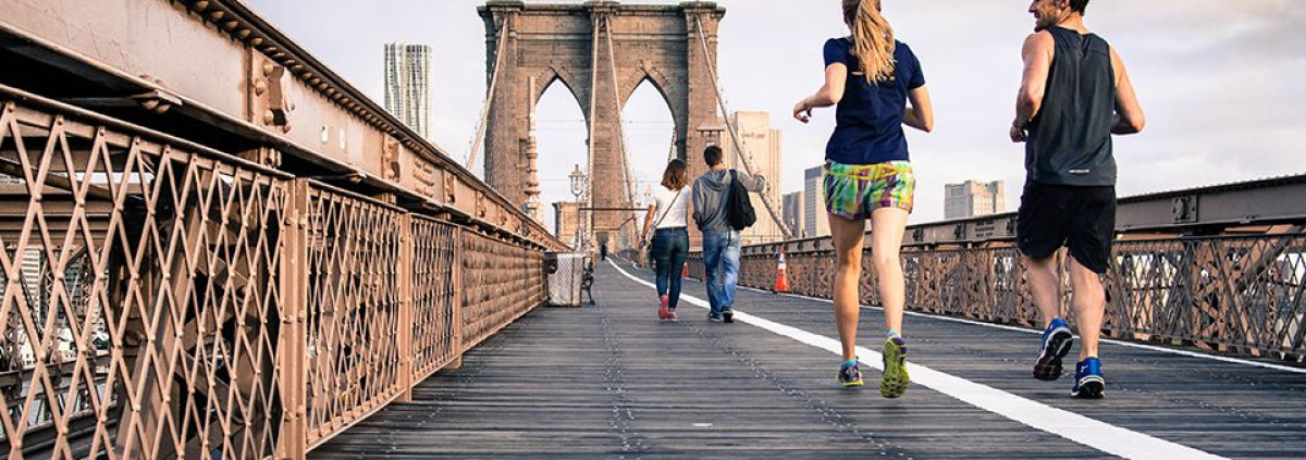 Two people jogging on a bridge